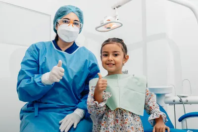 Niña sonriente en la consulta del dentista, odontopediatría